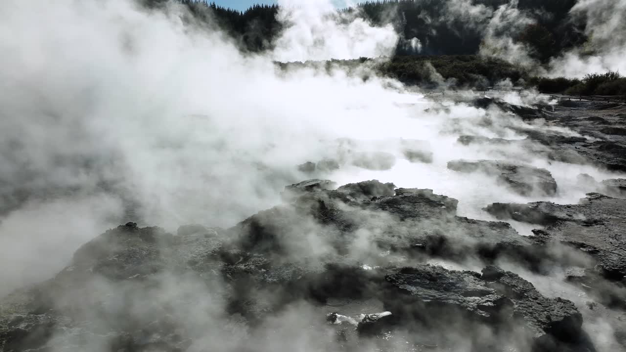 Boiling mud pools, Drone slowly flying over geothermal landscape. Trees, steam, bubbling mud and steam. Alien Landscape. Sci-fi. Global Warming