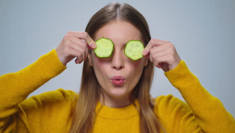 Retrato-De-Una-Mujer-Sonriente-Divirtiéndose-Con-Dos-Rodajas-De-Pepino-En-El-Estudio.