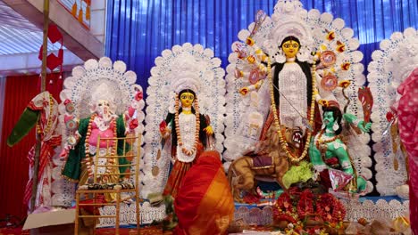 decorated hindu durga idol with devotees praying during dussehra in daylight