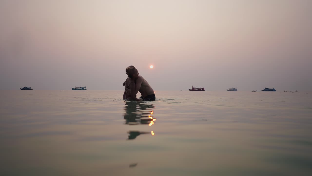 Romantic Couple Embracing in the Ocean at Sunset
