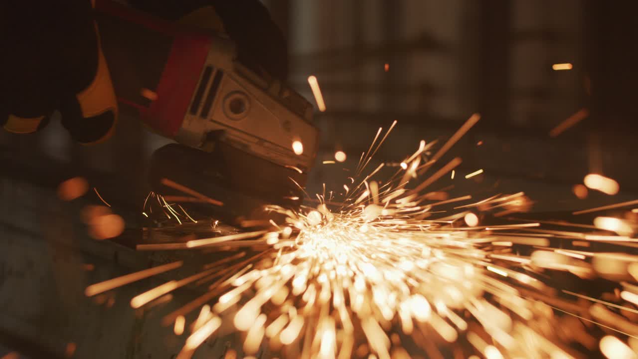 Construction worker grinding metal, closeup, slow motion
