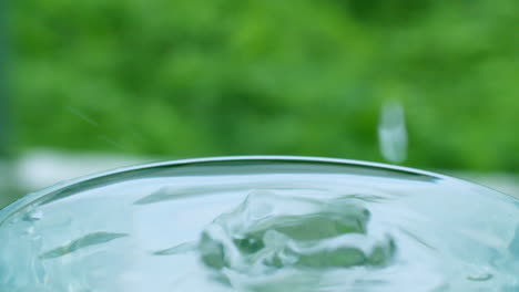 Tröpfchen,-Die-In-Ein-Bis-Zum-Rand-Mit-Wasser-Gefülltes-Glas-Fallen-Und-überlaufen,-Symbolisieren-Auch-Lebensspendend-Und-Fülle