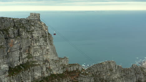 subir teleférico hacia la estación de teleférico de table mountain con el telón de fondo de la playa de camps bay en ciudad del cabo, sudáfrica