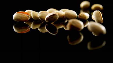 pistachios falling on black background 4k