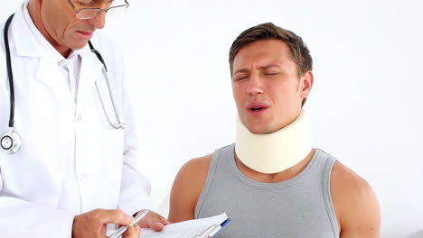 sportsman in neck brace being checked by doctor