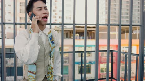 transgender men having fun doing talking on the phone with friend at the rooftop.