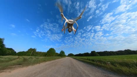 slow-motion-aufnahmen einer drohne, die niedrig über einer kiesstraße fliegt