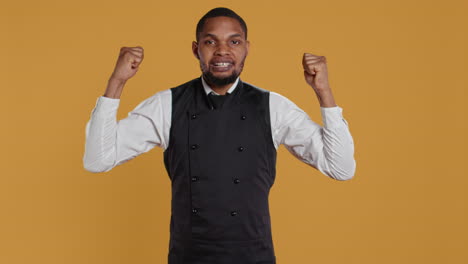 Waiter-flexing-his-muscles-and-showing-his-strength-in-studio