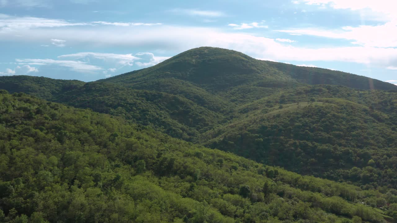 toma aérea volando sobre una gama de colinas en una tarde soleada brillante