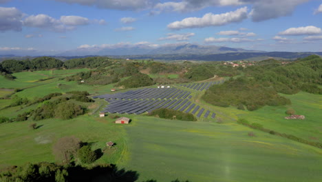 aerial: flying towards solar panels farm field of green renewable energy