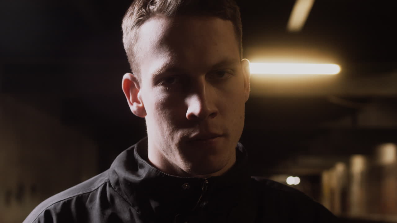 Close-up portrait of a man in a dark indoor setting