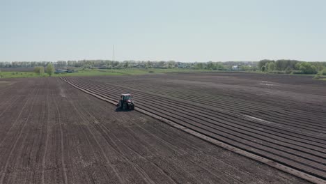 a tractor with blades cuts holes to prepare the field before planting. agricultural machinery.