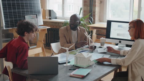 diverse engineers discussing renewable energy project at office meeting