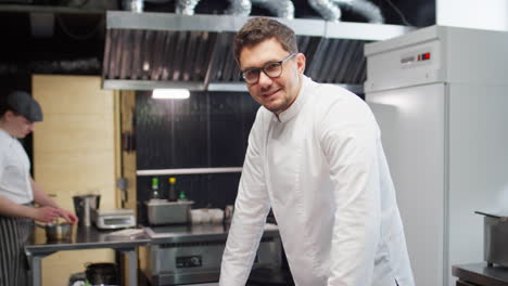 portrait of cheerful chef in restaurant kitchen
