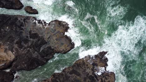 4k 30fps aerial footage of thor's well, spouting horn along the oregon pacific northwest coast - aerial view turquoise blue water, birds flying, waves crashing, rocks shimmering from setting sun