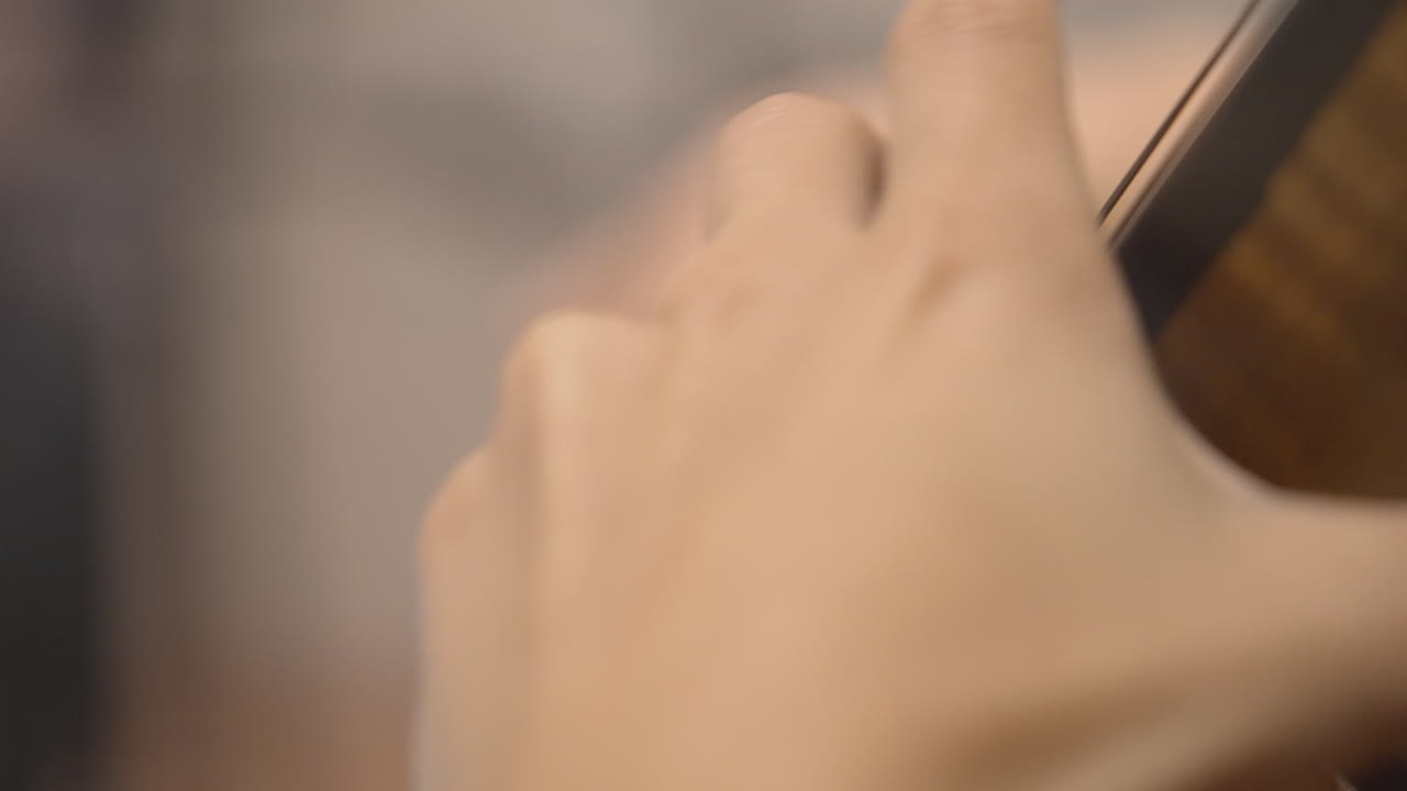 Close-up of a Musician's Hand Playing a String Instrument