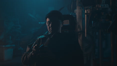 mysterious man in the workshop at night smokes a cigarette