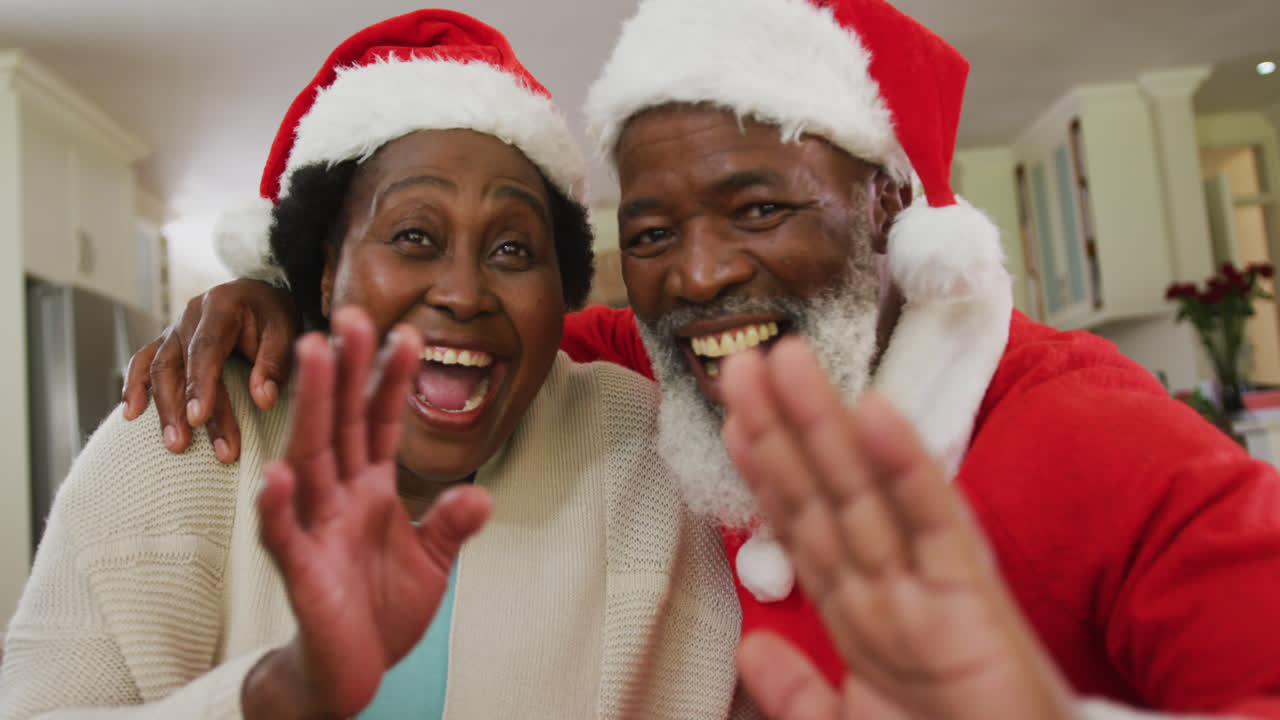 Portrait of african american couple at christmas time wearing santa hats