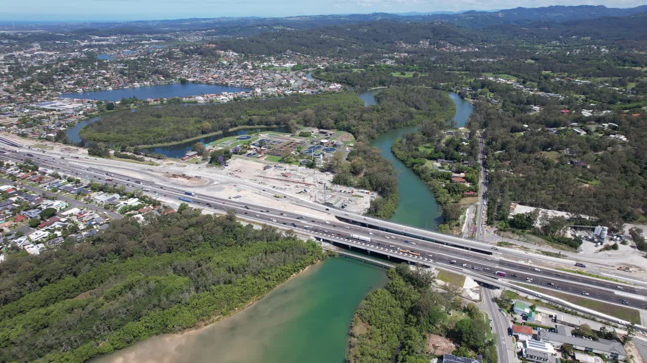 Traffic At Pacific Motorway With Elanora Wastewater Treatment Plant In QLD, Australia. - aerial shot