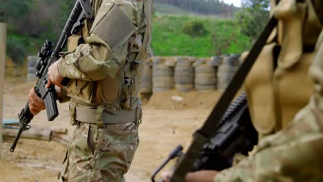 side view of mixed-race military soldiers rifle training in fields during military training 4k