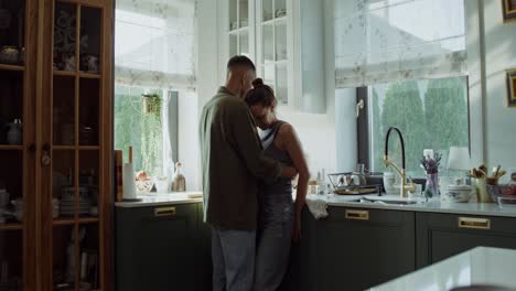 una pareja abrazándose en la cocina.