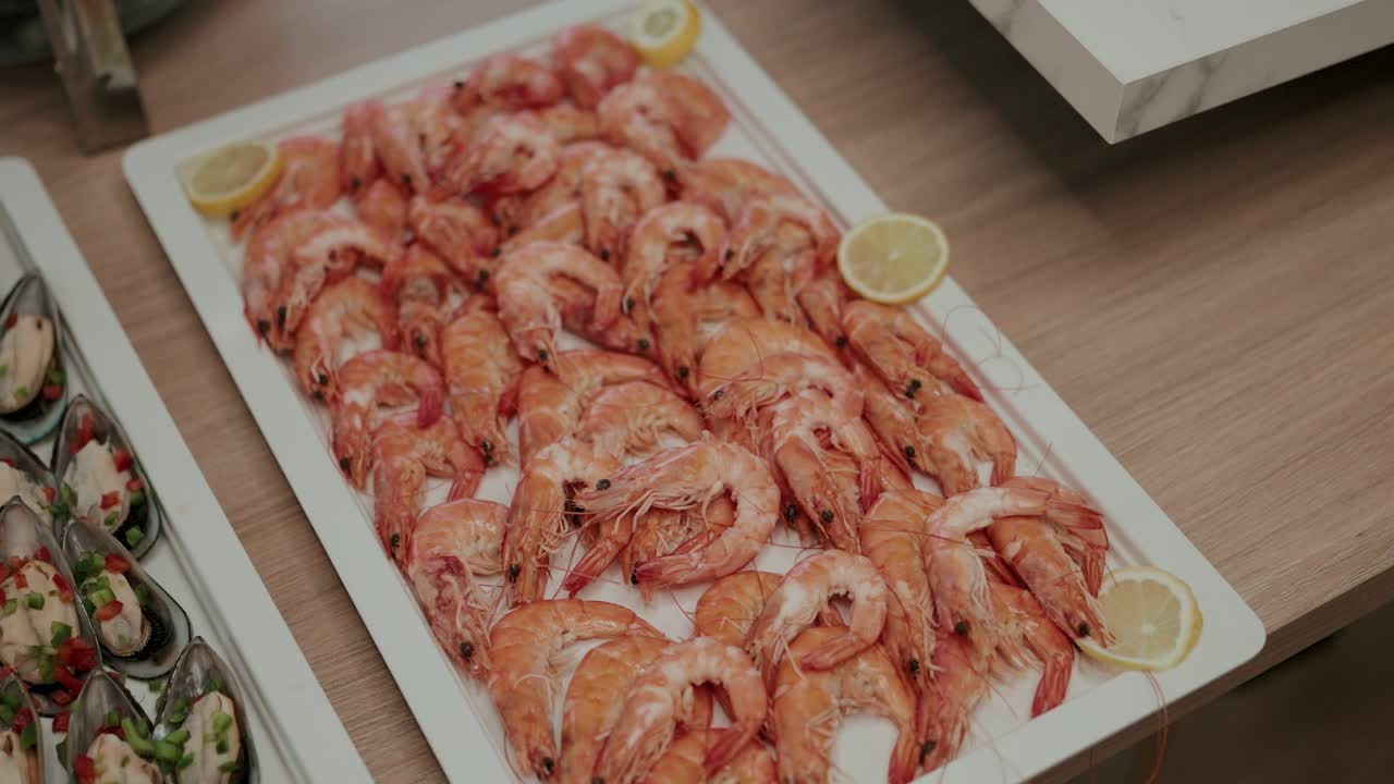 Close view of cooked prawns arranged on platter with lemon at buffet