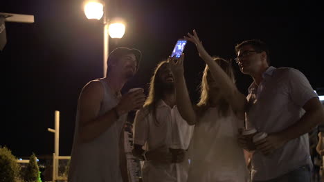 friends making mobile selfie in night street