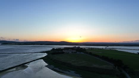 Approaching-the-Maguelone-cathedral-island-during-sunset-in-southern-France,-Aerial-dolly-in-shot