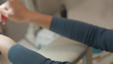 customer closely inspecting nails and preparing to hand them to nail technician for filing, showcasing detailed grooming moment with natural light and salon background emphasizing care and attention