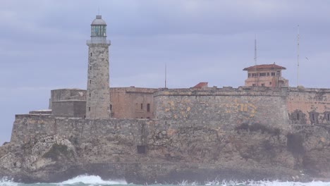 El-Castillo-Y-El-Fuerte-Del-Morro-En-La-Habana,-Cuba,-Con-Grandes-Olas-Rompiendo-En-Primer-Plano