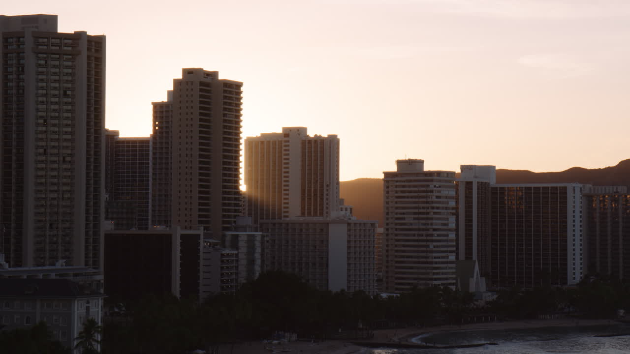 Brilho intenso do sol através de hotéis arranha-céus na Praia de Kuhio, Waikiki, Plano médio