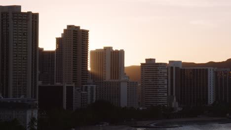 la brillante luz del sol florece a través de hoteles de gran altura en la playa de kuhio, waikiki, plano medio