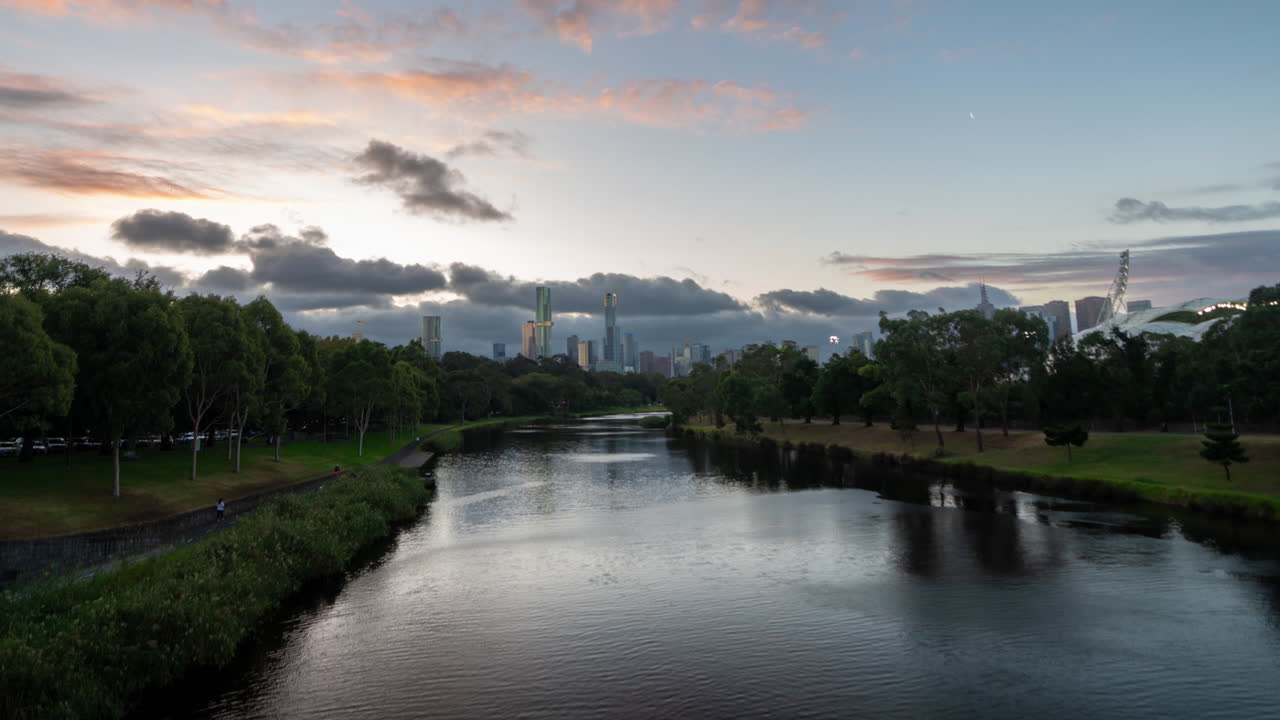 멜버른 식물원 (melbourne botanical garden) 의 호수와 시내의 초고층 빌라가 해가 지는 동안 구름 에 있습니다.