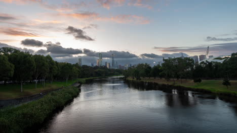 Timelapse,-Melbourne-Botanical-Garden-Lake-and-Downtown-Skyscrapers-Under-Clouds-at-Sunset,-Australia