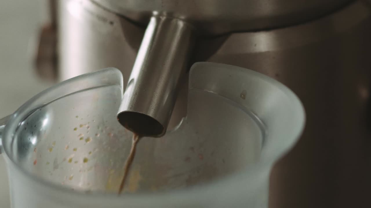 el jugo de vegetales frescos se vierte en una jarra de una máquina exprimidora