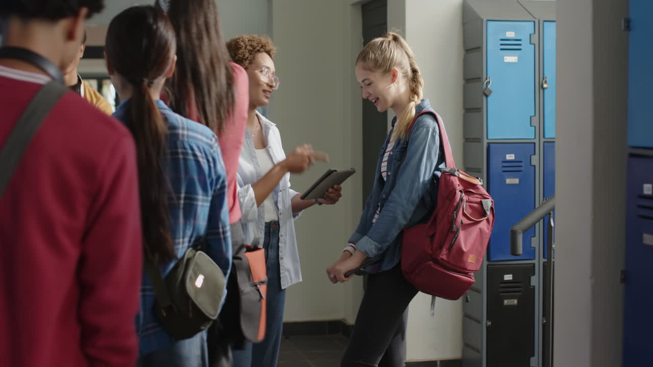 In high school, teenage girl with backpack smiling and talking with friends near lockers