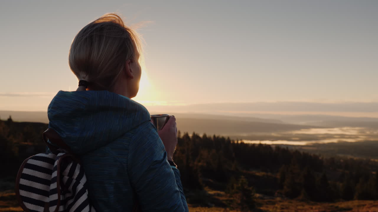 el viajero bebe té caliente en la cima de la montaña admirando el amanecer en el horizonte naturaleza de