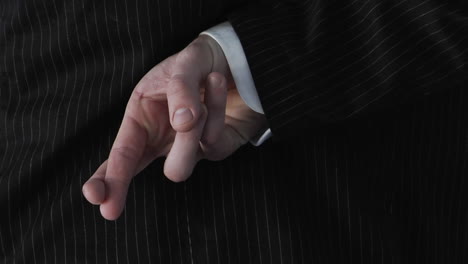 un hombre de negocios cruza los dedos detrás de la espalda 1