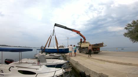 lifting boat from the sea with crane on a truck