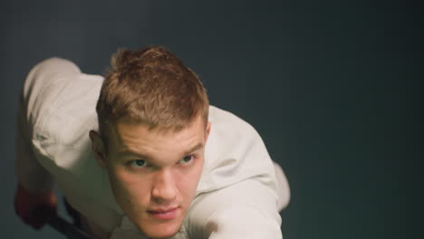 close-up shot of gentleman in white shirt displaying intense focus and concentration in dark background. eyes locked in determination, highlighting deep thought, precision, and serious demeanor