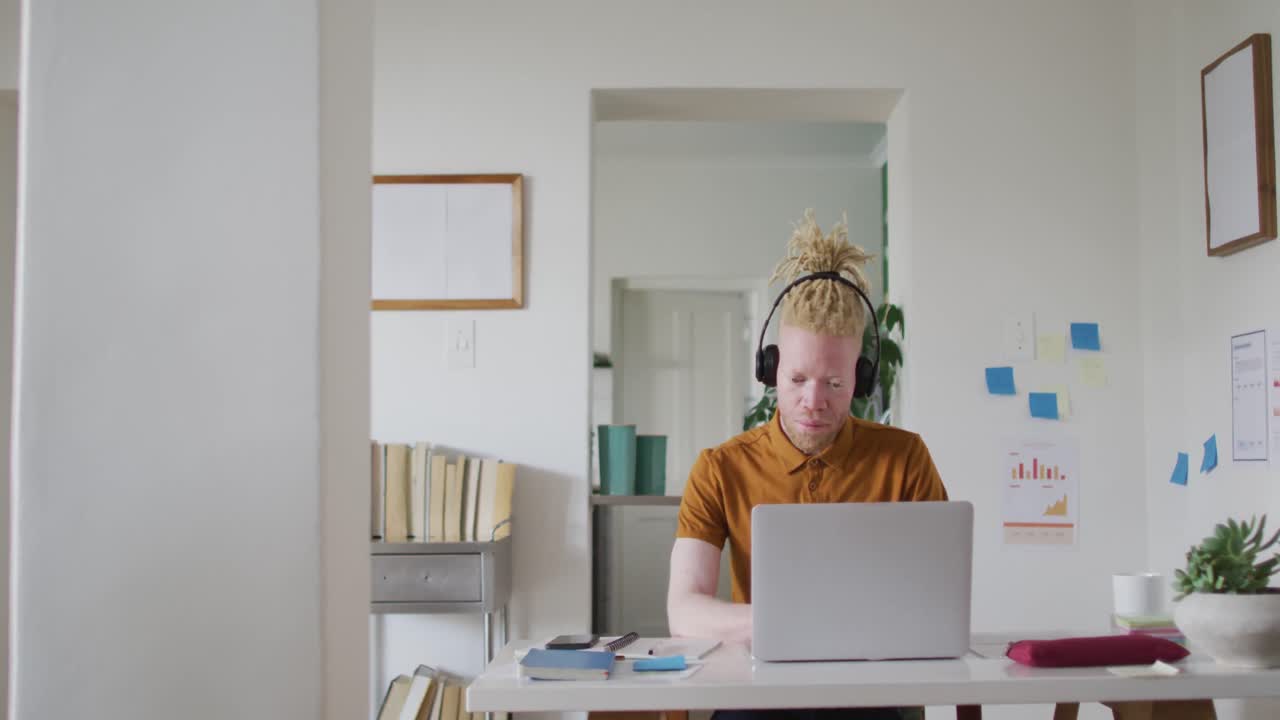Albino african american man with dreadlocks making video call on the laptop