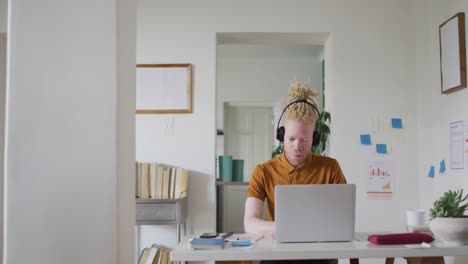 Albino-african-american-man-with-dreadlocks-making-video-call-on-the-laptop