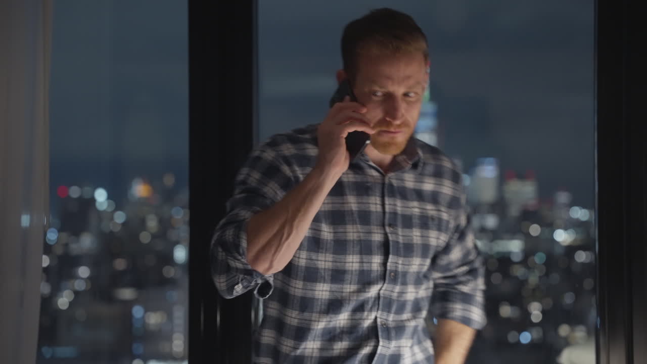 Man on Phone at Night with City View