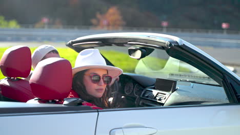 women enjoying a scenic road trip in a convertible