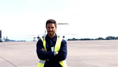 Portrait-of-aircraft-marshaller-standing-with-arms-crossed