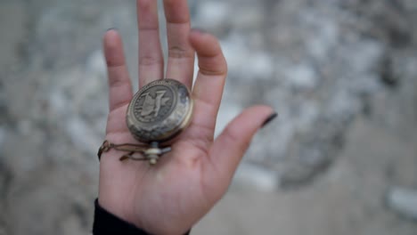 hand holding a pocket watch and compass