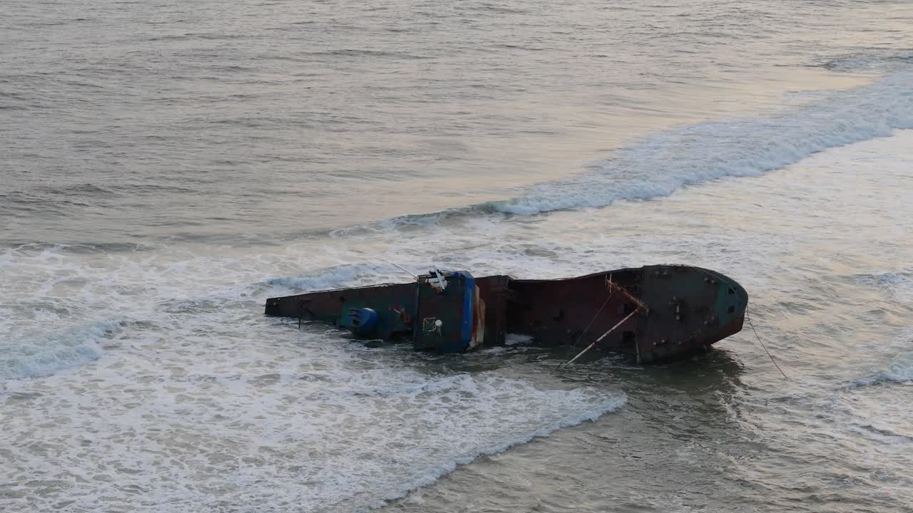 나이지리아 라고스에서 느린 동작으로 촬영된 해변에 부서진 은 배.