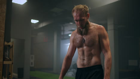 sweaty tired athlete with vapor in slow motion in the gym rests after training. restoring strength and breathing. motivation and sport