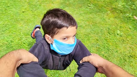 Asian-kid-masked-playing-,swing,-dancing-circle,-circling-the-child,-enjoying-and-cheers-in-park-during-the-lockdown-2nd-wave-of-coronavirus-in-india