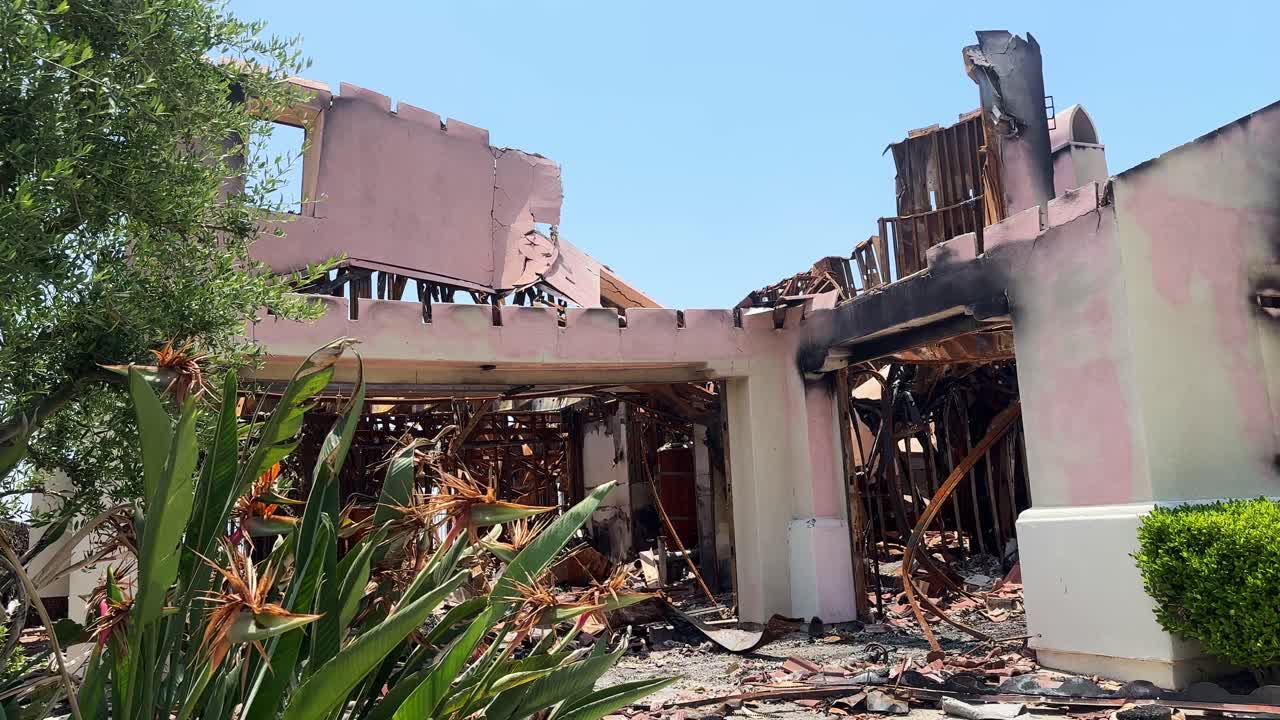 Handheld close-up panning shot of the ruins of a home burned by the Eaton Fire in Altadena, California. 4K